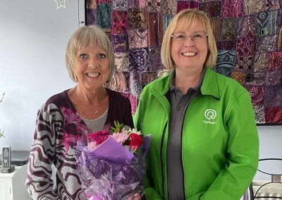 Customer Testimonial Tuesday, Meet Jill a NISEP Scheme Customer sharing her experience on an Oil to Gas Conversion Service. Jill (Left) holding flowers with Pippa (right)